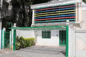 un bâtiment avec une porte verte devant lui dans l'établissement Hostel 33 Brazil, à Guarulhos