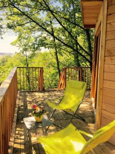 una terrazza con due sedie e un tavolo con fiori di Cabanes Sainte Camelle a Saint-Victor-Rouzaud