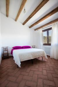a bedroom with a large bed in a room with a window at Case Vacanze S'Arrexina in Rudalza