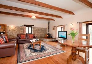 sala de estar con sofá y mesa en Callestock Courtyard Cottages, en Truro