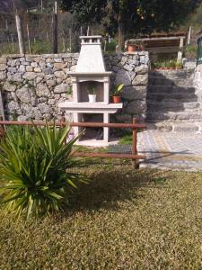 a bird house in front of a stone wall at Casa do Soutinho in Beiral do Lima