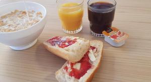 una mesa con un sándwich y dos vasos de zumo en Centre International de Séjour en Laval