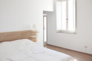 a white bedroom with a bed and a window at Santa Maria Suites in Rome