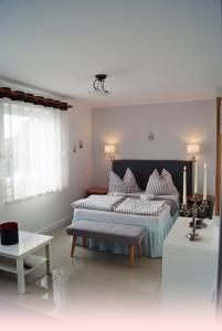 1 dormitorio con 1 cama grande y 1 mesa en IWONA Pokoje Apartamenty, en Karwia