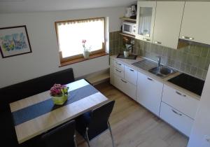 uma cozinha com uma mesa de madeira e um lavatório em Apartments Zorč em Bohinj