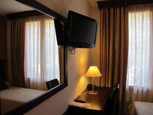 Una televisión o centro de entretenimiento en Hotel Turmo