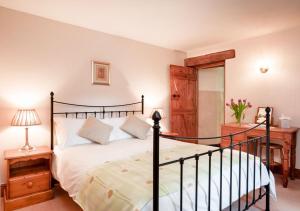 1 dormitorio con 1 cama y escritorio con lámpara en Callestock Courtyard Cottages, en Truro