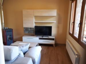 a living room with a couch and a tv at APARTAMENTOS CAMINO SANTO TORIBIO in Mieses
