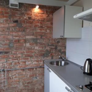 a kitchen with a brick wall and a sink at Апартаменты с панорамным видом на город in Zaporozhye