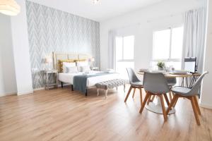 a bedroom with a bed and a table and chairs at Suite Premium - Cathedral of Malaga in M&aacute;laga
