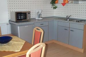 eine kleine Küche mit einem Tisch und einer Mikrowelle in der Unterkunft Fewo Keilhofer in Spiegelau
