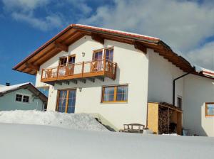 a house with a balcony in the snow at Fewo Keilhofer in Spiegelau