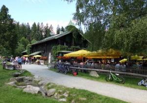 a group of people sitting outside of a building with umbrellas at Fewo Keilhofer in Spiegelau