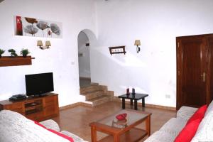 a living room with a couch and a tv at Villa Susan Ibiza in San Antonio