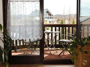 een veranda met een stoel en een tafel op een balkon bij Ferienwohnung Schillinger in Sasbach am Kaiserstuhl