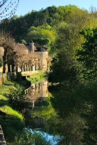 uitzicht op een rivier met een dorp op de achtergrond bij Coté-Serein La Privilège de la Tour Madame in Noyers-sur-Serein