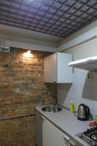 a kitchen with a sink and a brick wall at Апартаменты с панорамным видом на город in Zaporozhye