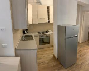 a kitchen with white cabinets and a stainless steel refrigerator at Ca du Sergio - Le Mura in Levanto