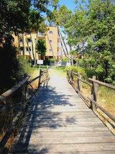 カヴァッリーノ・トレポルティにあるCorallo Apartmentsの塀と建物のある木道