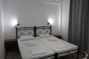 a bedroom with a bed with two white pillows on it at Zeus Hotel in Iraion