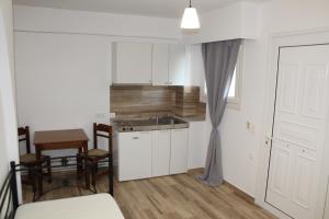 a kitchen with a sink and a table and a table and chairs at Zeus Hotel in Ireon