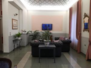 uma sala de estar com sofás e uma televisão em Hotel Prati em Montecatini Terme