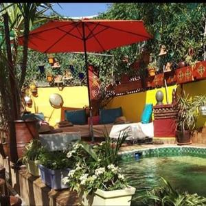 une terrasse avec un parasol et une piscine dans l'établissement Riad Laith, à Marrakech