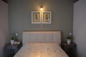 een slaapkamer met een bed met twee tafels en een lamp bij Romanza Studios in Asos