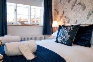 a bedroom with a bed with blue pillows and a window at The Annexe with Hot Tub in Maidstone