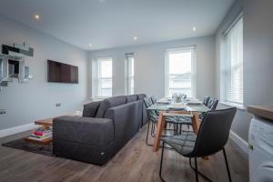 a living room with a couch and a table at Gordon Moon Suites Bolton Centre Apartments in Bolton