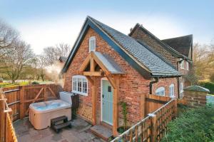 a small brick house with a toilet on a patio at The Annexe with Hot Tub in Maidstone