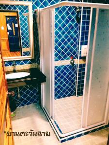 La salle de bains est pourvue d'une douche et d'un lavabo. dans l'établissement Baan Tawan Shine Surin, à Surin