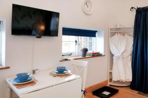 a living room with a tv on a wall at The Annexe with Hot Tub in Maidstone