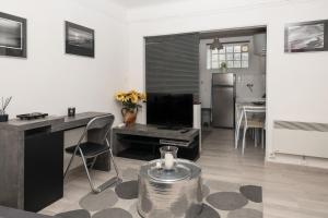uma sala de estar com uma televisão, uma secretária e uma mesa em Studio avec vue sur les arénes em Arles