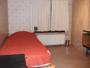 1 dormitorio con cama roja y ventana en GUESTROOMS BIJ HET STATION VAN DRONGEN, en Gante