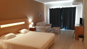 a bedroom with a bed and a chair in a room at Vilamar in Luz
