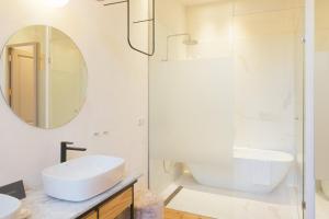 ein weißes Badezimmer mit Waschbecken und Spiegel in der Unterkunft VEINTIUNO Emblematic Hotels by Airnest in Las Palmas de Gran Canaria