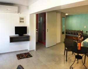 salon z telewizorem, stołem i krzesłami w obiekcie Sea Front Studio - Porto Boufalo - Evia w mieście Boufalo