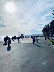 Un groupe de personnes marchant dans une rue près de la plage dans l'établissement Villa Bagatelle - Luxury apartment, à Nice