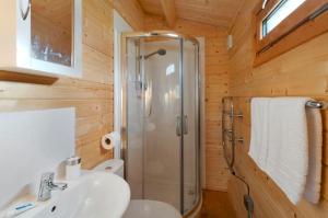 a bathroom with a shower and a sink at The Cabin with Hot Tub in Maidstone