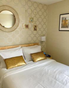 a bedroom with a large white bed with a mirror at Hotel Mimosa in New York