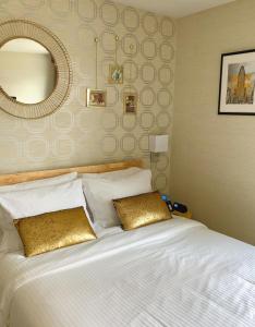 1 dormitorio con 1 cama blanca grande y espejo en Hotel Mimosa, en Nueva York