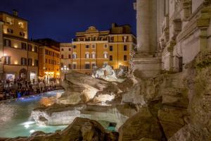 a view of a fountain in a city at night at Trevi Ab Aeterno - Amazing View of the Trevi Fountain in Rome