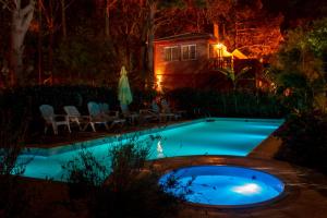 a swimming pool at night with a house in the background at Cabañas MARE PARADISO in Costa del Este