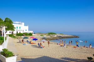 a group of people sitting on a beach at Terrazza sul mare in Villanova di Ostuni