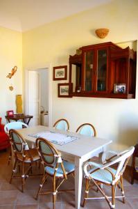 a dining room with a white table and chairs at Terrazza sul mare in Villanova di Ostuni