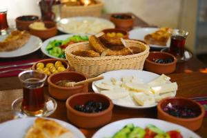 a table with plates of food and bowls of food at Ados Hotel in Cesme