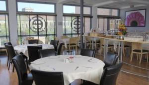 a restaurant with white tables and chairs and windows at Executive Hotel in Forlì