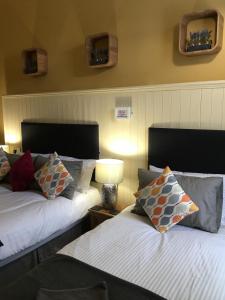 um quarto com 2 camas com almofadas e um candeeiro em The Residence - NO 57 em Edimburgo
