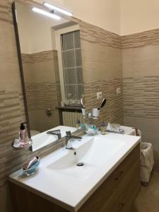 uma casa de banho com um lavatório branco e um espelho grande em B&B da nonna Vincenza em Vinchiaturo
